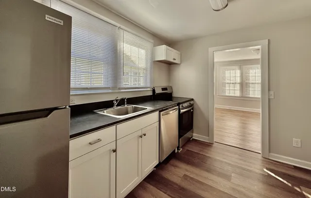 a kitchen with granite countertop a sink and cabinets