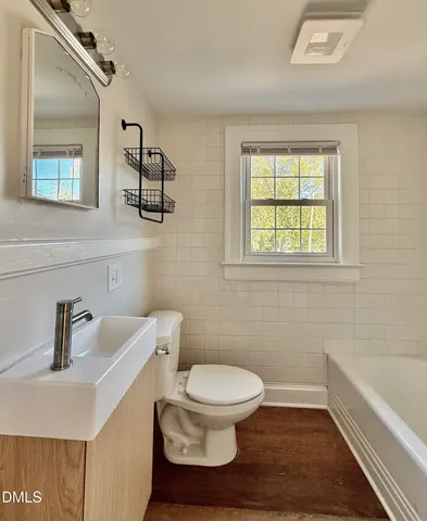 a bathroom with a toilet a sink and mirror