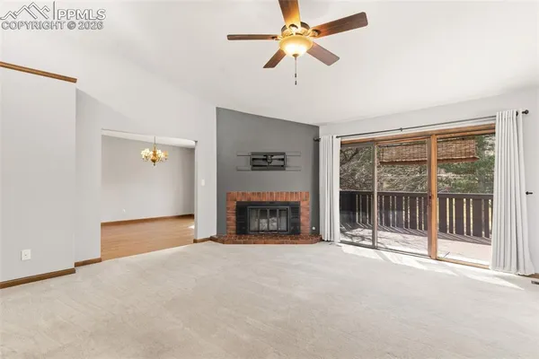 a view of an empty room with a fireplace and a window