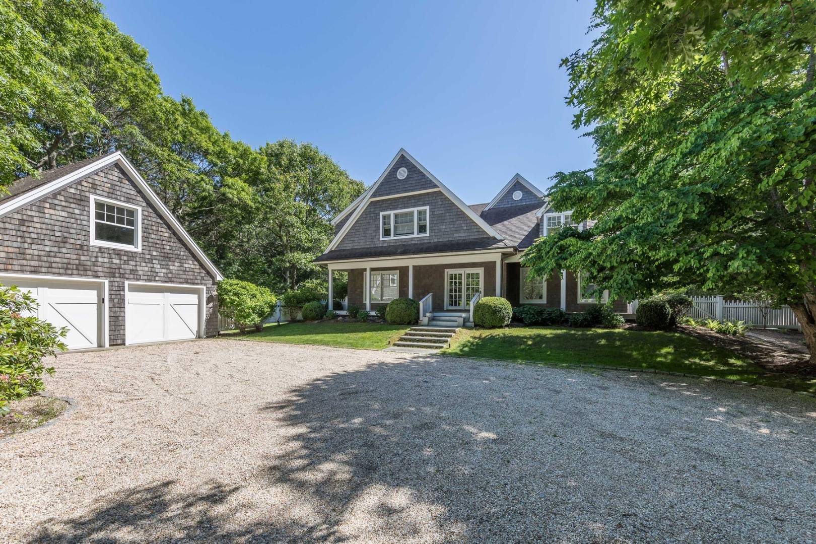 a front view of a house with a yard and trees