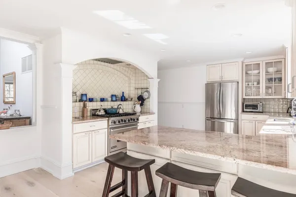 a kitchen with stainless steel appliances kitchen island granite countertop a refrigerator and stove