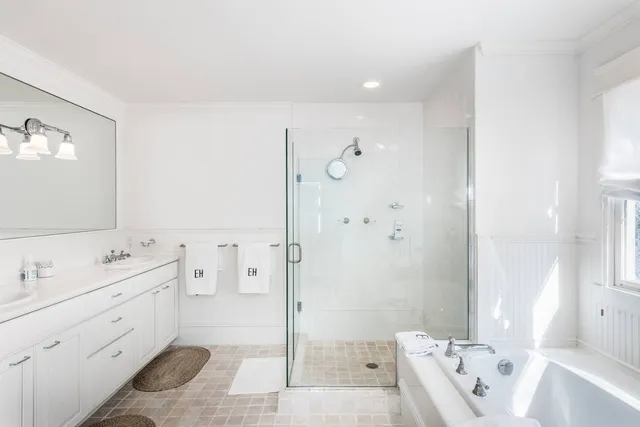 a bathroom with a tub sink and mirror