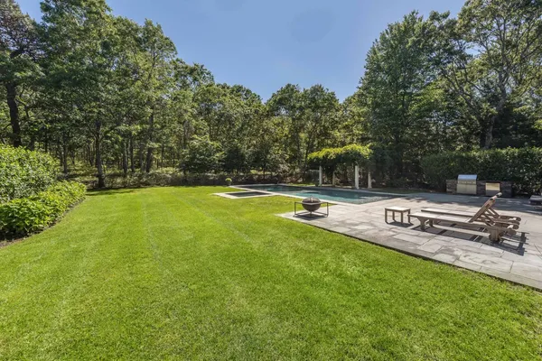 a view of a swimming pool with a bench and trees around