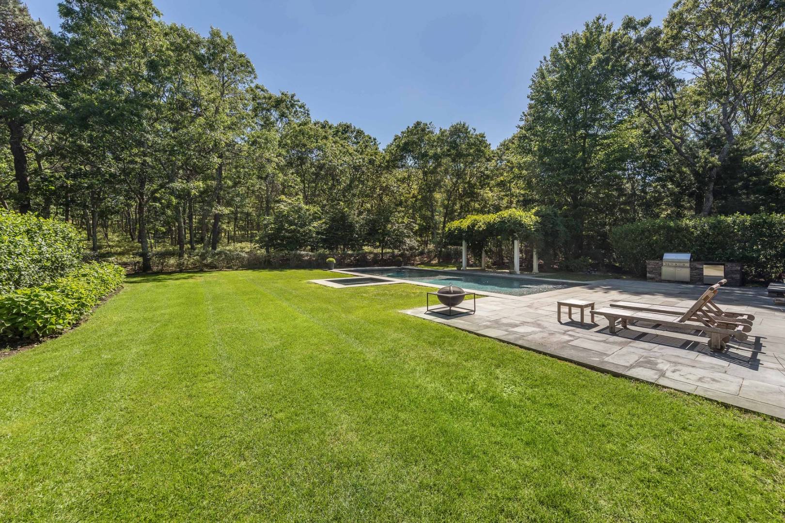 17 Long Hill Road East Hampton, NY 11937 - Photo 10 of 10 a view of a swimming pool with a bench and trees around