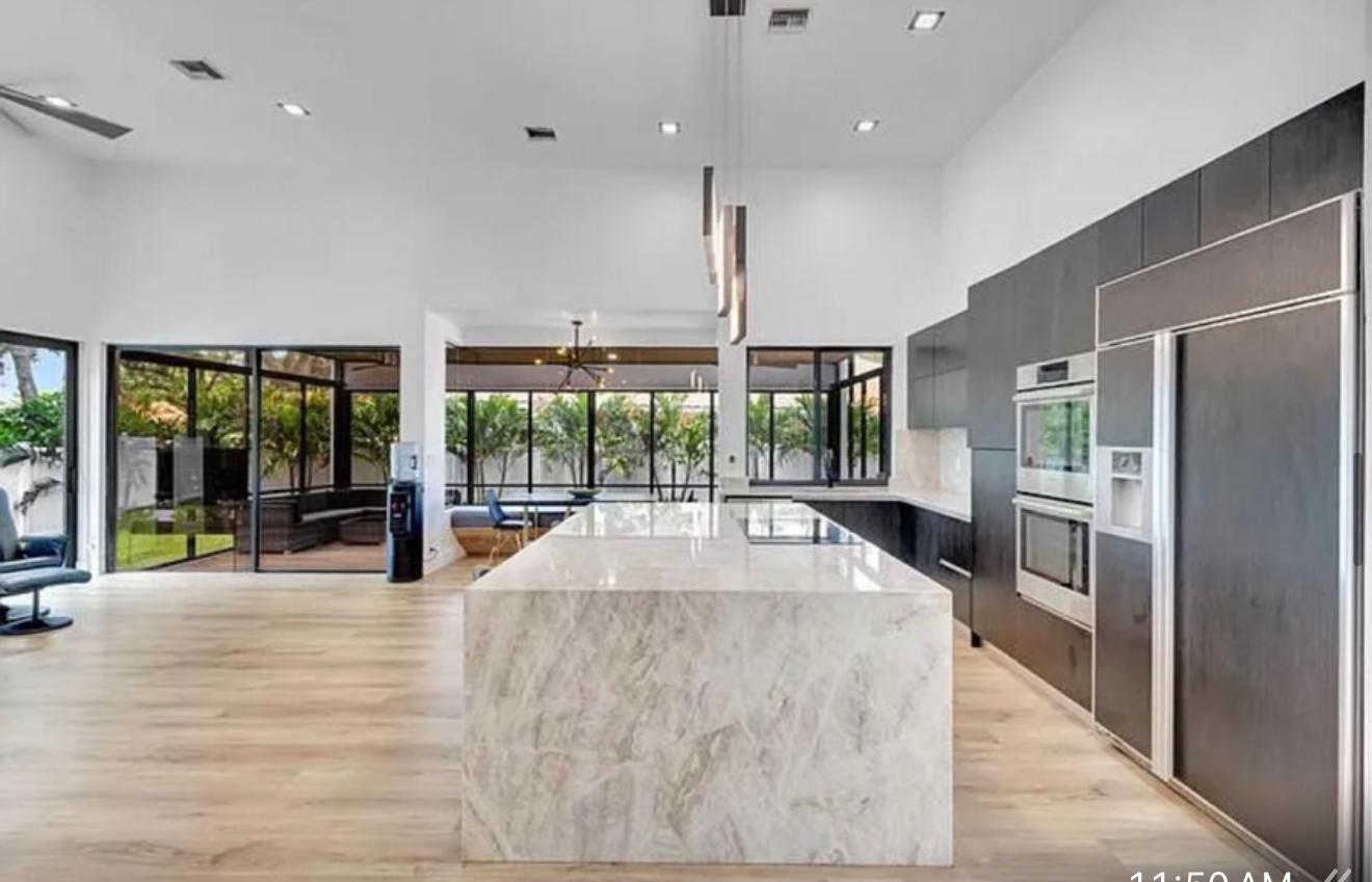 2299 Northwest 55th Street Boca Raton, FL 33496 - Photo 13 of 47 a view of a kitchen with large windows and a refrigerator