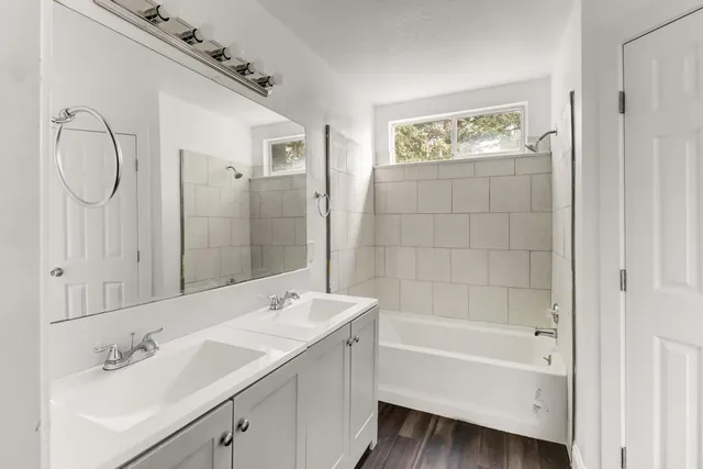 a bathroom with a tub sink and mirror