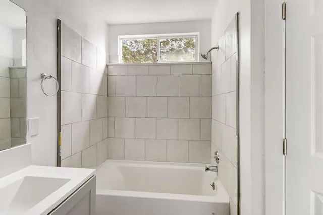 a bath tub sitting next to a white sink and a shower