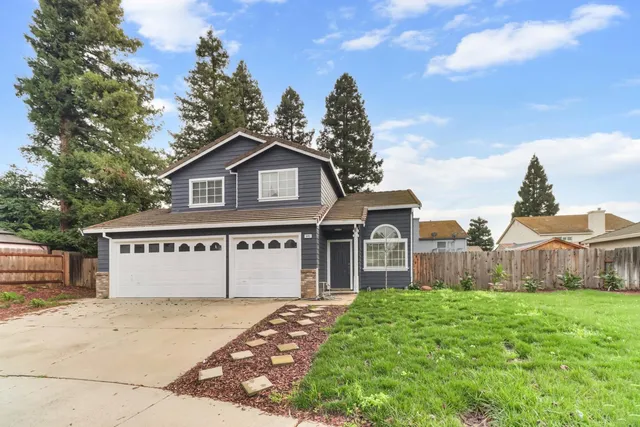 a view of a house next to a yard with big trees