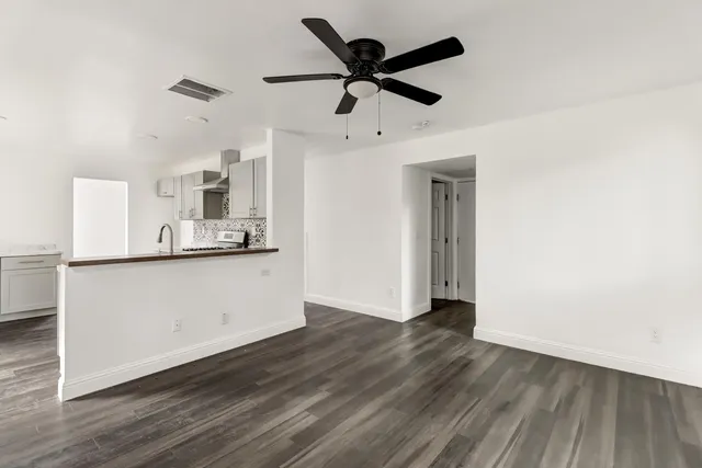 a view of a kitchen with wooden floor and a ceiling fan