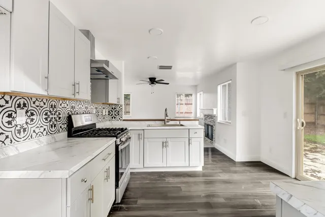 a kitchen with granite countertop a sink stove and cabinets