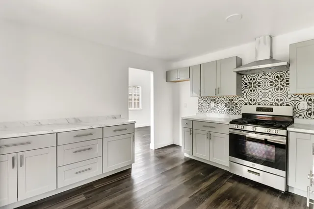 a kitchen with granite countertop white cabinets and white appliances