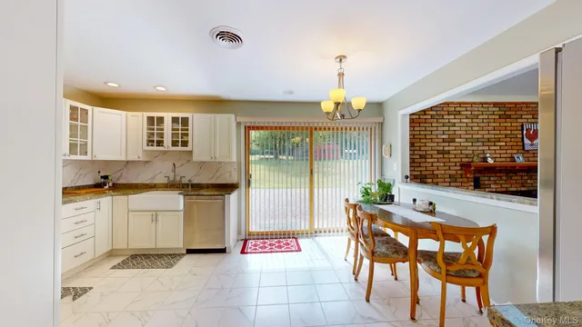 a kitchen with a dining table chairs and white cabinets
