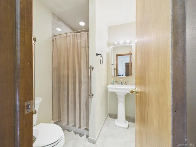 a bathroom with a sink a toilet and shower