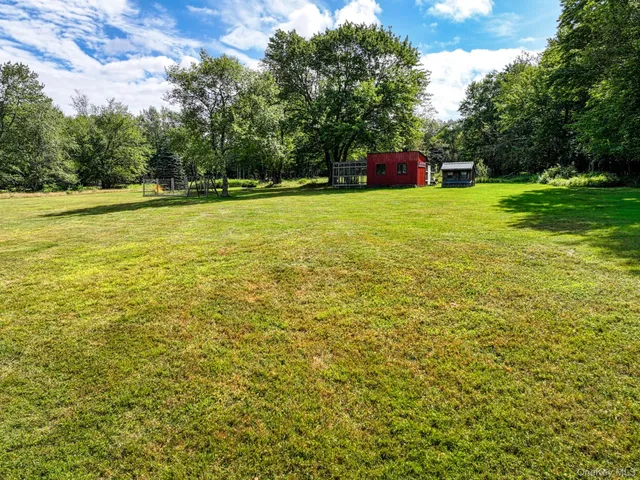a view of a field with trees in the background