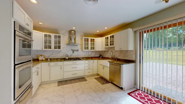 a kitchen with stainless steel appliances granite countertop sink stove and cabinets