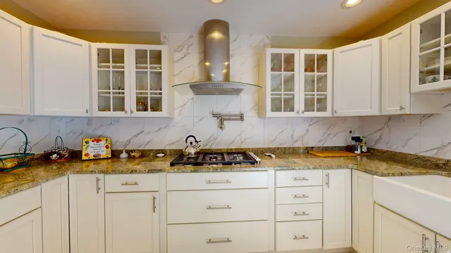 a kitchen with stainless steel appliances granite countertop white cabinets and a sink
