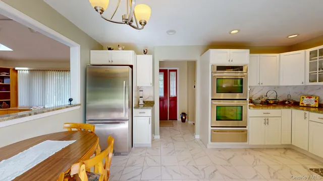 a kitchen with stainless steel appliances granite countertop a refrigerator and a stove top oven
