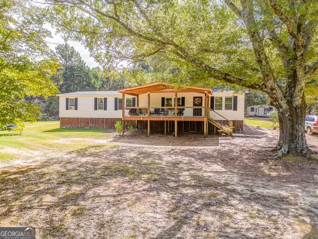 a front view of a house with a garden and trees