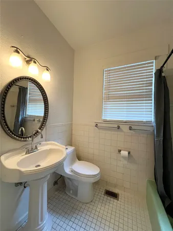 a bathroom with a sink toilet and a mirror