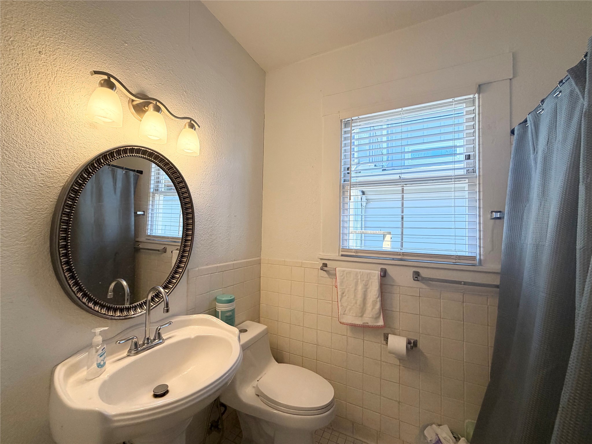 407 West 35th Street, Unit A Austin, TX 78705 - Photo 15 of 20 a bathroom with a toilet a sink and a mirror