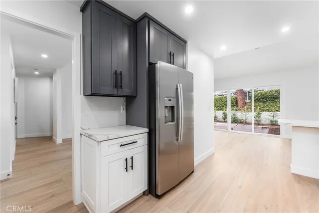 a kitchen with stainless steel appliances a refrigerator and wooden floor