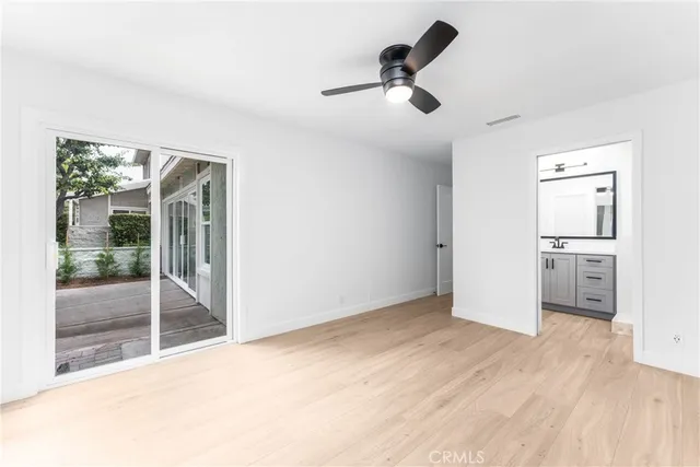 a view of empty room with wooden floor and windows