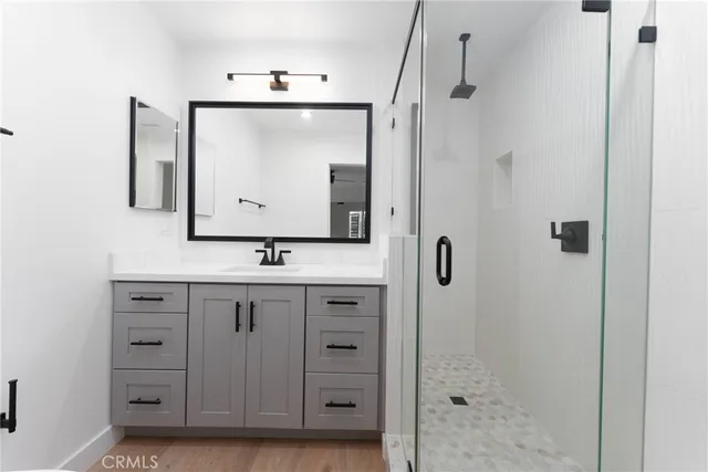 a bathroom with a sink a mirror a vanity and shower