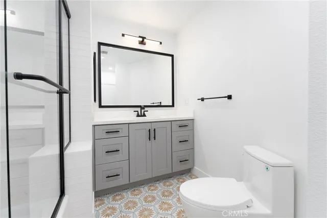 a bathroom with a toilet a sink and mirror