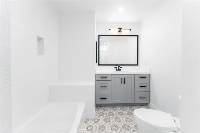 a bathroom with a sink a toilet and mirror