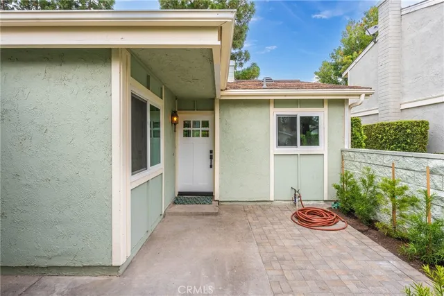 a view of a small house with potted plants