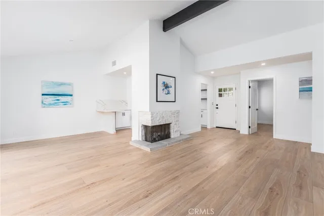 a view of a livingroom with wooden floor and a fireplace