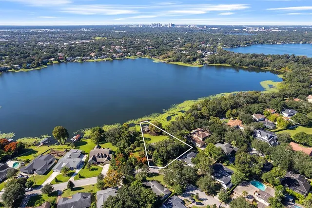 an aerial view of a houses with a lake