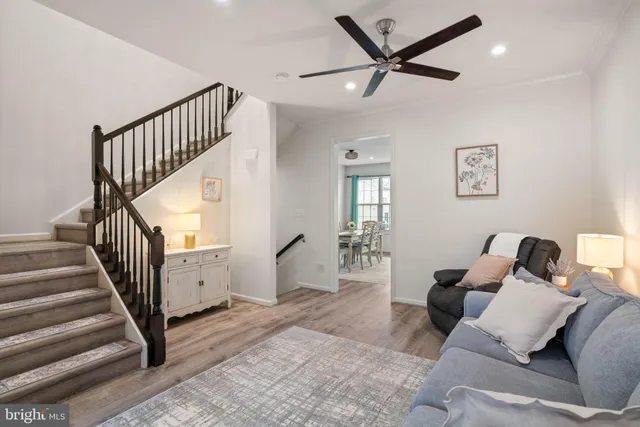 a living room with furniture and a ceiling fan