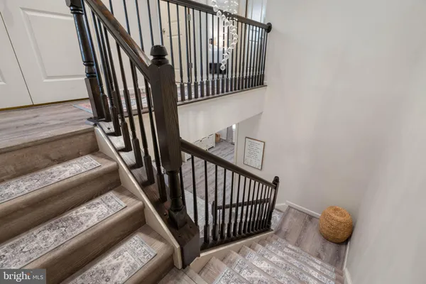 a view of staircase with wooden floor and a rug