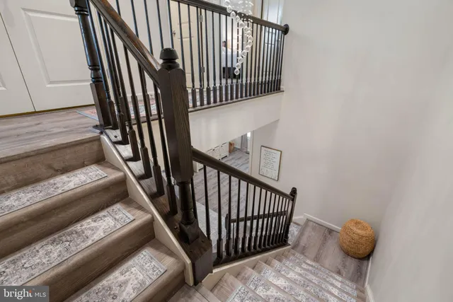a view of staircase with wooden floor and a rug