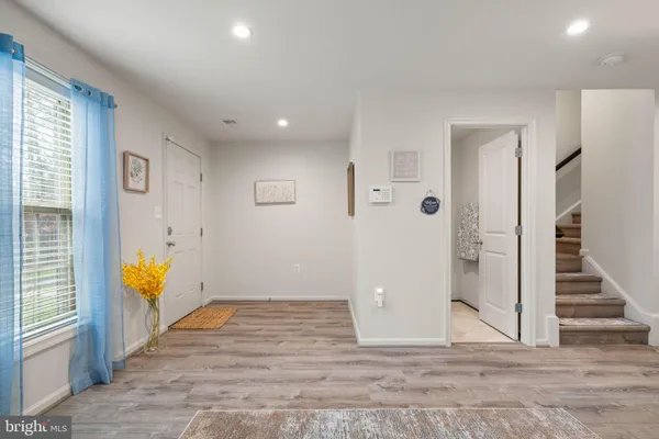 an empty room with wooden floor and a ceiling fan