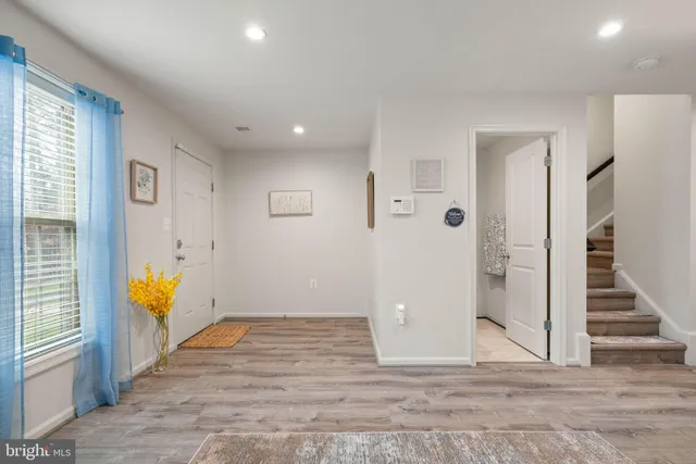 an empty room with wooden floor and a ceiling fan