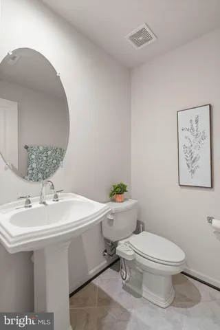 a bathroom with a sink toilet and a mirror