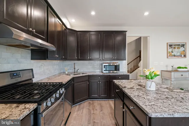 a kitchen with granite countertop stainless steel appliances and wooden cabinets