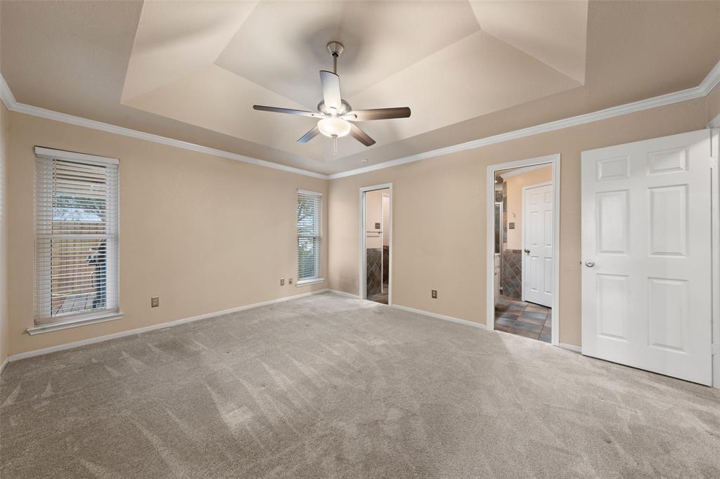 712 North Old Robinson Road Robinson, TX 76706 - Photo 11 of 26 Unfurnished bedroom with ornamental molding, ensuite bathroom, a ceiling fan, carpet flooring, and a raised ceiling