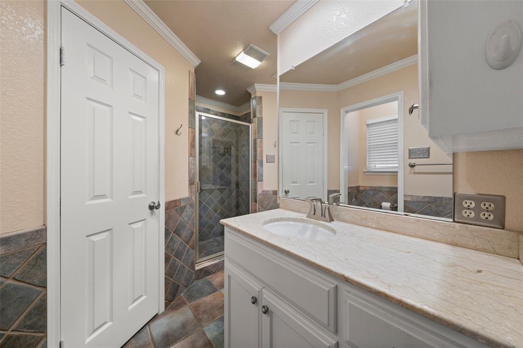 712 North Old Robinson Road Robinson, TX 76706 - Photo 13 of 26 Bathroom with vanity, a shower stall, crown molding, tile walls, and wainscoting