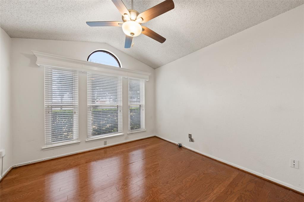 712 North Old Robinson Road Robinson, TX 76706 - Photo 16 of 26 Unfurnished room with vaulted ceiling, a textured ceiling, ceiling fan, and wood finished floors