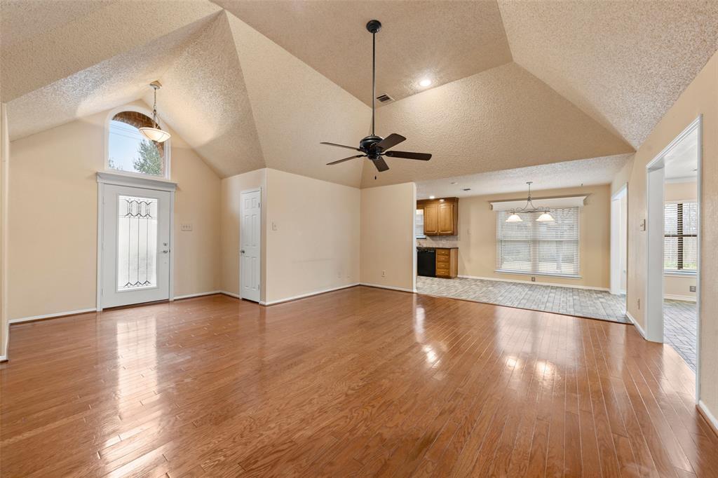 712 North Old Robinson Road Robinson, TX 76706 - Photo 3 of 26 Unfurnished living room with light wood-style floors, a textured ceiling, a chandelier, ceiling fan, and high vaulted ceiling