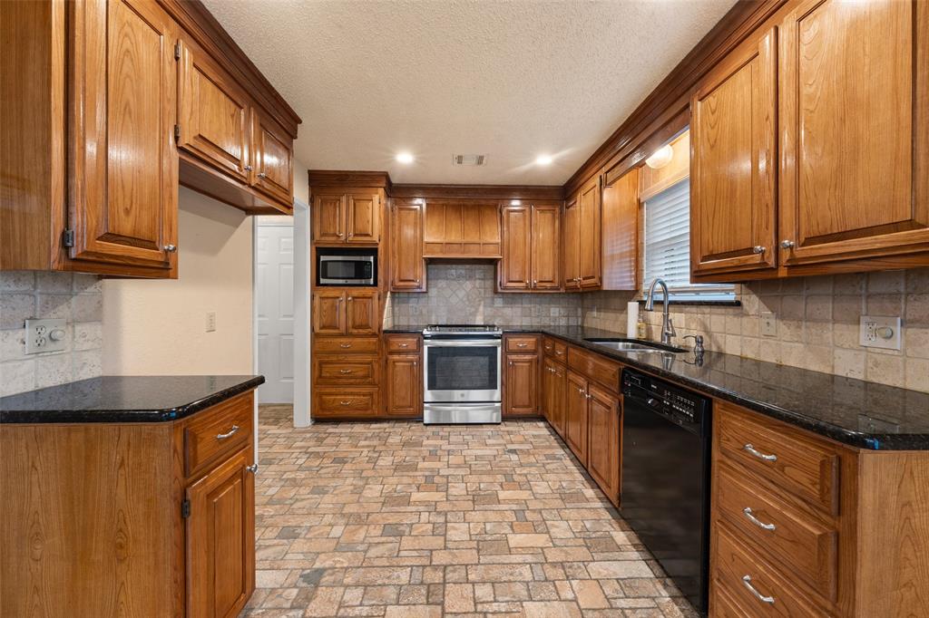 712 North Old Robinson Road Robinson, TX 76706 - Photo 5 of 26 Kitchen featuring brown cabinetry, stainless steel appliances, recessed lighting, dark stone countertops, and decorative backsplash