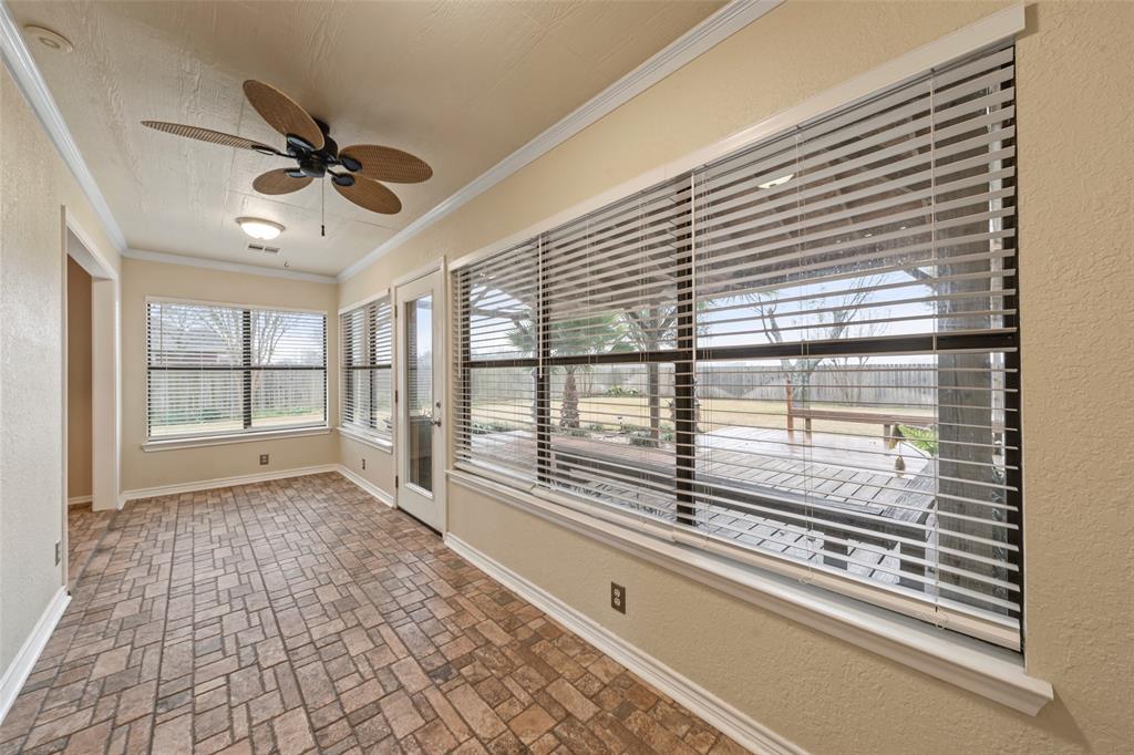 712 North Old Robinson Road Robinson, TX 76706 - Photo 9 of 26 Unfurnished sunroom featuring brick patterned flooring, a textured wall, and crown molding