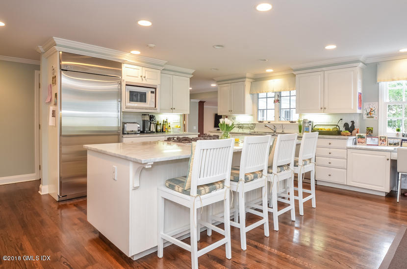 16 Willow Road Riverside, CT 06878 - Photo 10 of 30 a kitchen with stainless steel appliances kitchen island granite countertop a table chairs sink and cabinets