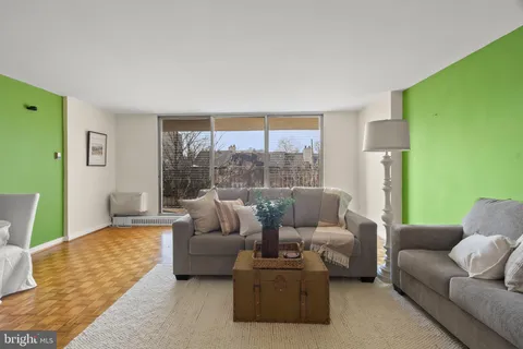 a living room with furniture and a view of kitchen