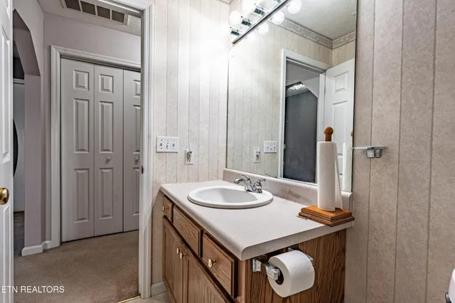 an empty room with a chandelier fan and windows