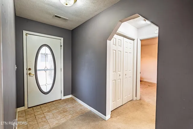 a view of a hallway with wooden floor and a bathroom
