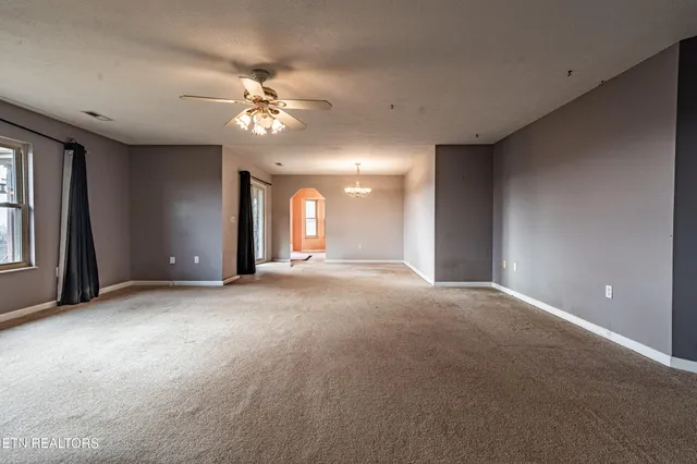 a view of a livingroom with a ceiling fan and window